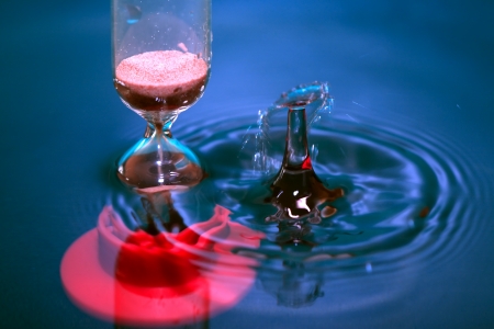 Flow time. Hourglass in blue splashing water