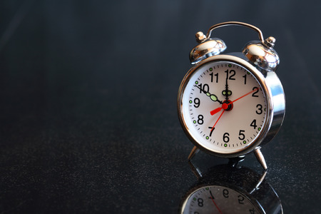 Alarm clock on dark background with free space for text
