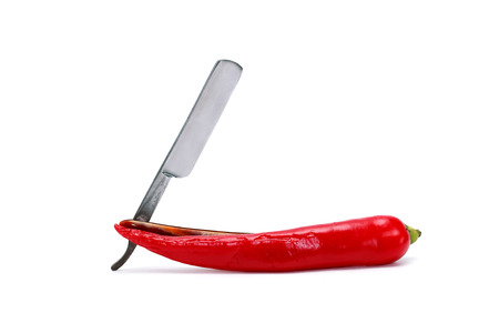 Red chili pepper and straight razor on white background. の写真素材