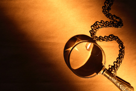 Vintage magnifying glass on nice old paper backgroundの写真素材