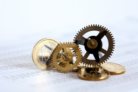 Euro coins and gears on paper background with digits tableの写真素材