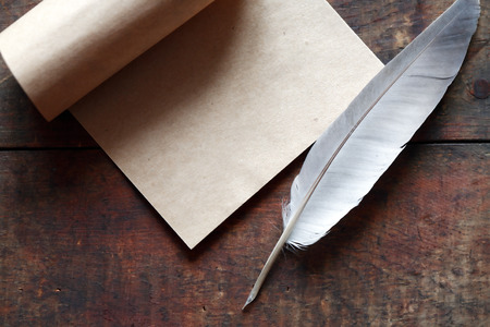 Paper and quill pen on nice old wooden backgroundの写真素材