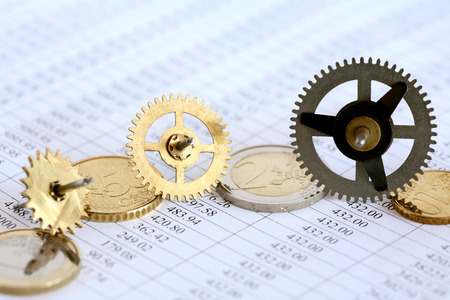 Euro coins and gears on paper background with digits table