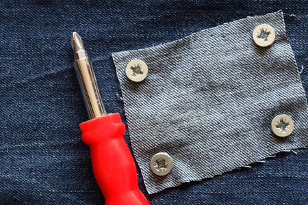 Patch attached to denim background with metal screwsの写真素材