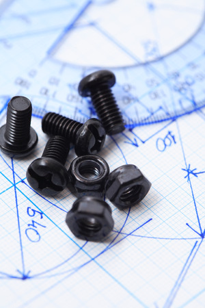 Industry concept. Set of black bolts and screw-nuts on graph paper with chartの写真素材