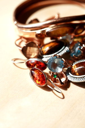 Set of various jewelry on wooden background under sunlightの写真素材