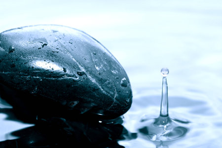Meditation concept. Stone with drops in splashing waterの写真素材