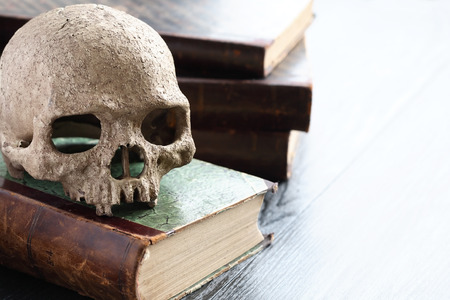 Death concept. Still life with human skull on old booksの写真素材