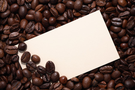 Closeup of empty paper card on coffee beans backgroundの写真素材