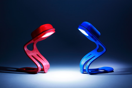 Contact. Red and blue glowing lamps with beam of light on dark backgroundの写真素材