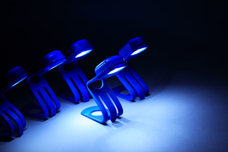 Few blue glowing lamps in a row on dark background