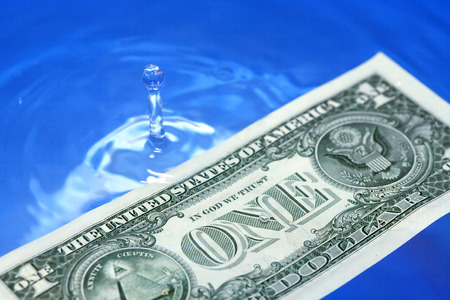 Closeup of one USA dollar bill on waving water surfaceの写真素材