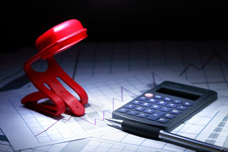 Business strategy. Closeup of calculator and and pen near glowing lampの写真素材