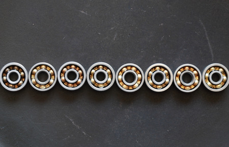 Industrial concept. Few ball bearings on dark metal background