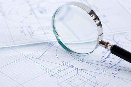 Closeup of magnifying glass on blueprint with draftの写真素材