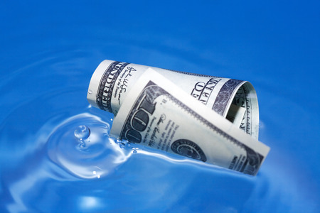 Closeup of one hundred USA dollar bill on waving water surfaceの写真素材