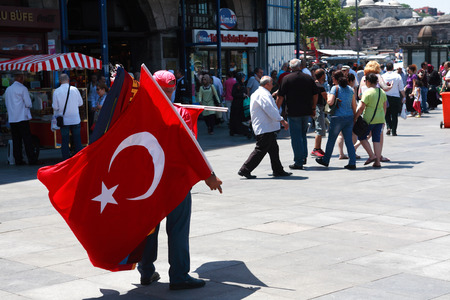 Istanbul, Turkey  July 7, 2015: Vendor with Turkish flags for sale on Eminonu squareのeditorial素材