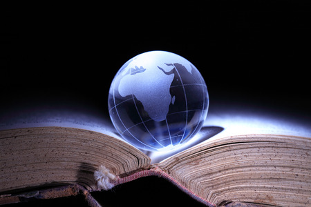 World Literature Concept. Glass globe on old book on dark backgroundの写真素材