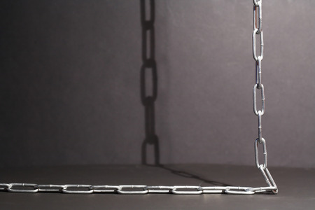 Metal chain with shadow on dark background