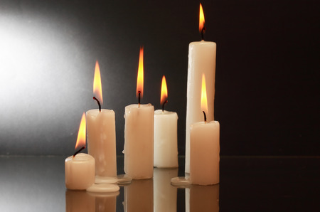 Few lighting candles with reflection on dark backgroundの写真素材