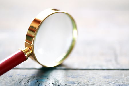 Magnifying glass closeup on wooden surfaceの写真素材