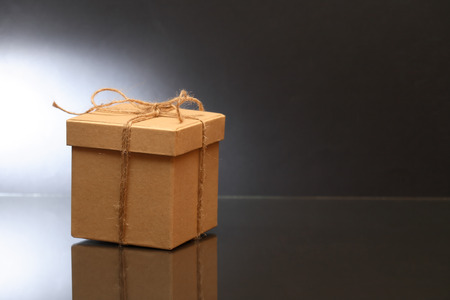 Cardboard box tied with twine on dark background