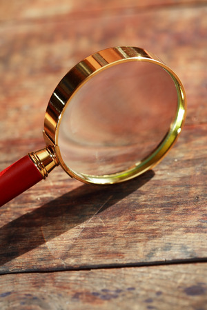 Magnifying glass with long shadow on wooden backgroundの写真素材