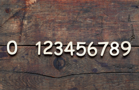 Set of wooden digits in a row on wood backgroundの写真素材
