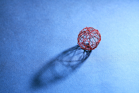 One ball made from red wire with shadow on dark backgroundの写真素材
