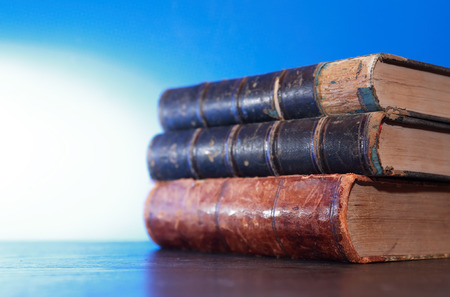 Stack of old books on blue background with free spaceの写真素材