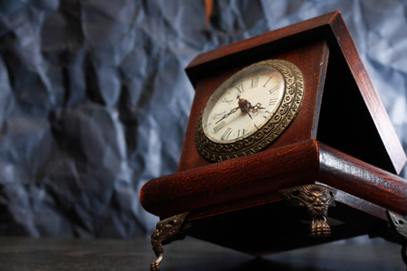 Old wooden casket with clock on nice gray background