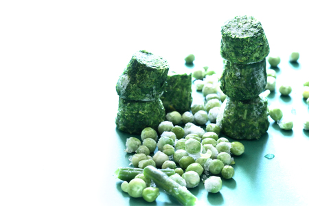 Frozen spinach and pea closeup on green backgroundの写真素材