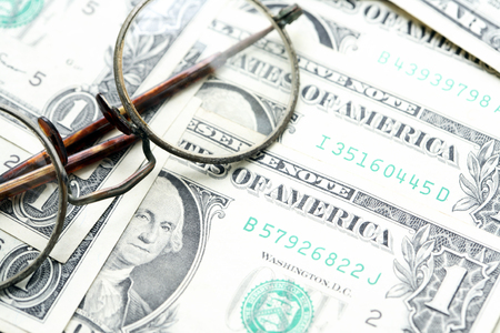 Old spectacles on dollar cash backgroundの写真素材