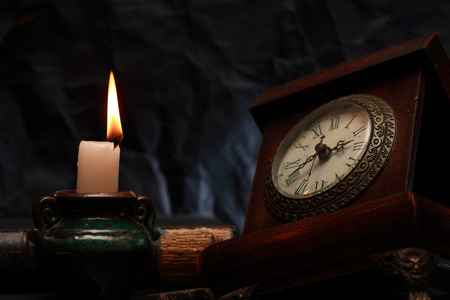 lighting candle near old clock