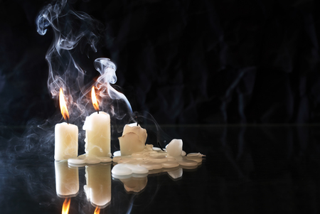 Set of extinguished candles with fire and smoke on nice dark backgroundの写真素材