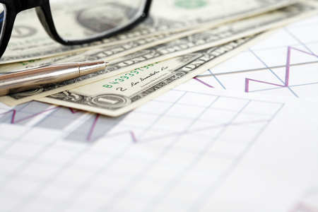 One USA dollar set and spectacles on paper background with graphの写真素材