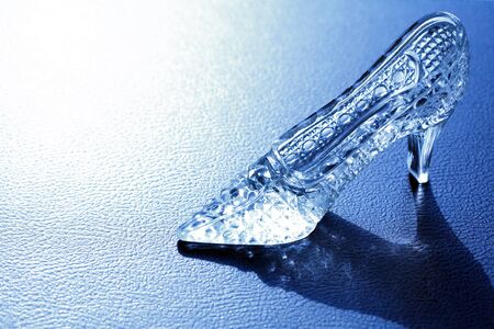 One nice glass slipper on blue background with shadowの写真素材
