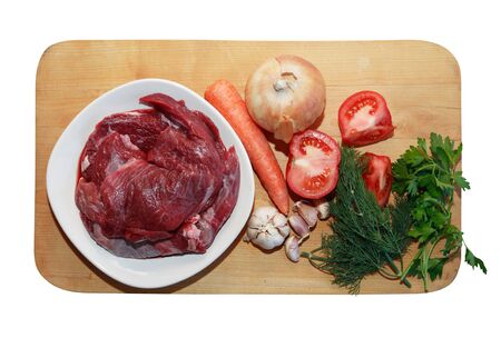 Portion of raw beef meat for cooking near vegetablesの写真素材