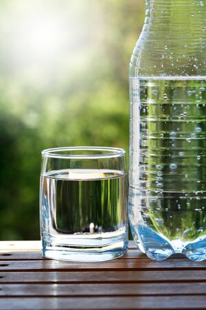 Cold mineral water against nice green nature backgroundの写真素材