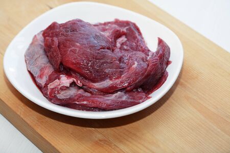 Portion of raw beef meat for cooking on white plateの写真素材