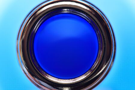 Conceptual background. Top view of the glass bottle neck against blueの写真素材
