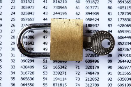 Financial security concept. Padlock and key on white plastic card with digitsの写真素材