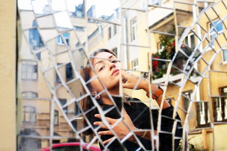 The beauty girl's reflection in the mirror on building wallの写真素材
