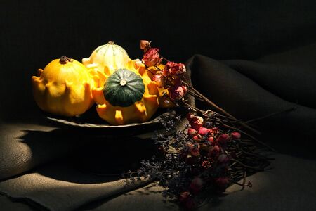 Vintage still life with few small pumpkins in old metal bowlの写真素材