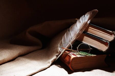 Vintage still life with old books and spectacles on canvas backgroundの写真素材
