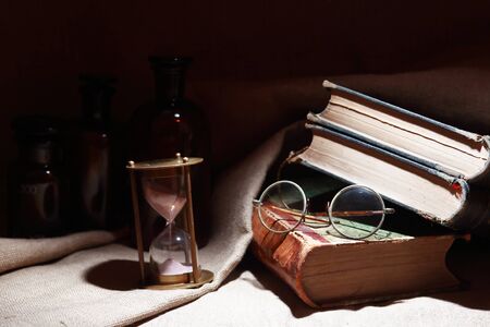 Vintage still life with old books and spectacles on canvas backgroundの写真素材