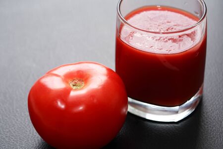 Full glass of tomato juice on nice gray backgroundの写真素材