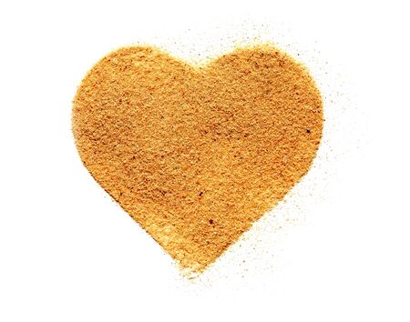 Heart symbol made from sand on white backgroundの写真素材