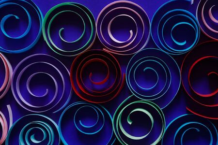Multicolored spirals made from paper on blue backgroundの写真素材