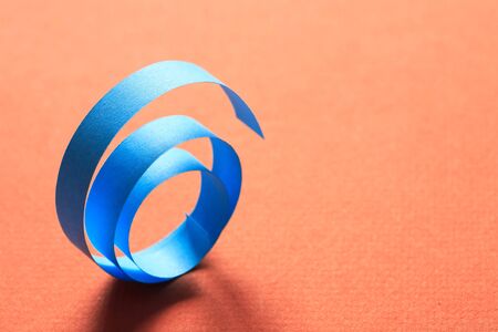 One blue spiral made from paper on red backgroundの写真素材